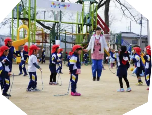 園庭で縄跳びをする幼稚園児たち